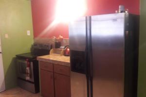 a kitchen with a stainless steel refrigerator and a stove at Spacious Home in Couva