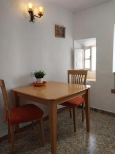 un tavolo in legno con due sedie e una pianta sopra di Casa TRIGO a Cómpeta