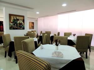 una sala da pranzo con tavoli, sedie e un dipinto di Grand Hotel Victoria a El Morro de Barcelona