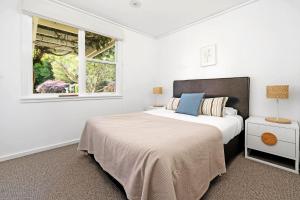 a white bedroom with a bed and a window at Glen Regan Berrima in Berrima