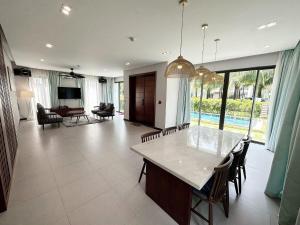 een grote woonkamer met een tafel en stoelen bij Hoang Hai Villas 3 Phu Quoc - 3 Bedrooms - Private Swimming Pool in Phu Quoc