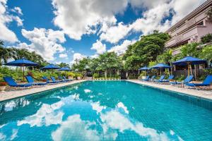 a swimming pool with blue chairs and umbrellas at Shigira Bayside Suite Allamanda in Miyako Island
