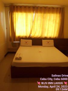 a bedroom with two beds and a window at WJV INN LAHUG in Tabok