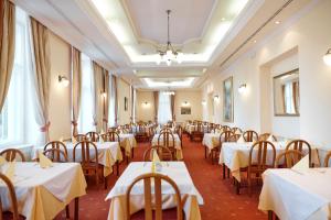 a dining room with white tables and chairs at Hotel Lovran in Lovran