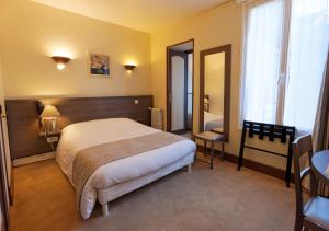a hotel room with a bed and a desk at Cit'Hotel Hôtel Beauséjour in Cherbourg en Cotentin