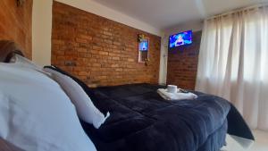 a bedroom with a large bed with a brick wall at Hospedaje Maria Valentina in Tota