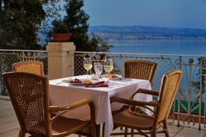 a table with glasses of wine on a balcony at Hotel Lovran in Lovran