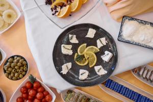 a table with a plate of cheese and fruit at Hotel Lovran in Lovran