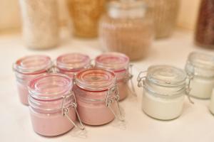 a group of jars filled with pink and white sauces at Hotel Lovran in Lovran