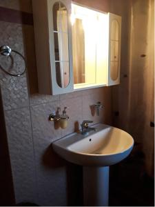 a bathroom with a sink and two mirrors at Vasiliki in Dhílesi