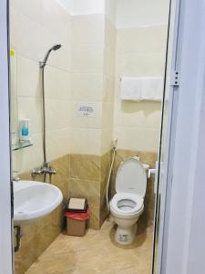 a bathroom with a toilet and a sink at DANA BEACH Motel in Da Nang