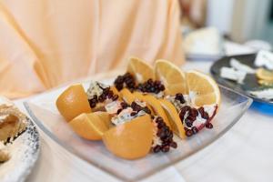 a plate with oranges and other fruit on a table at Hotel Lovran in Lovran