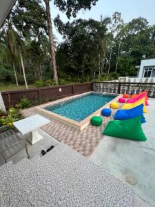 a swimming pool with colorful pillows and a table at BSK Bungalows in Lipa Noi