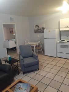 a living room with a chair and a kitchen at Stagecoach Suites in Wickenburg