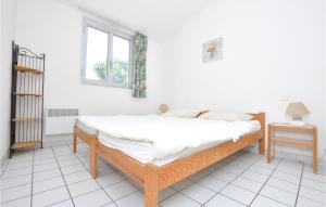a bed in a white room with a window at Amazing Apartment In Sainte-Maxime in Sainte-Maxime