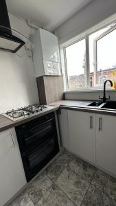 a small kitchen with a stove and a sink at Cozy home in a peaceful area in Hayes