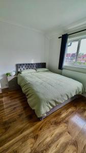 a bedroom with a large bed and a wooden floor at Cozy home in a peaceful area in Hayes