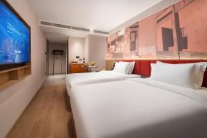 Un pat sau paturi într-o cameră la From K Huan Kai Hotel Tiyuxi Metro Station