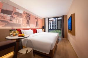 a hotel room with a large bed and a table at From K Huan Kai Hotel Tiyuxi Metro Station- Free transportation during the Canton Fair in Guangzhou