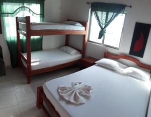 a bedroom with two bunk beds and a window at COVEÑAS PLAYAS TROPICALES in Coveñas