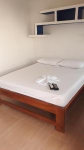 a bed with a white mattress with a wooden frame at COVEÑAS PLAYAS TROPICALES in Coveñas