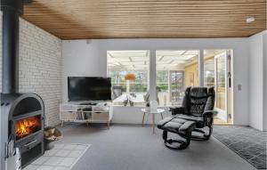 a living room with a chair and a fireplace at Holiday Home Teglager K-674 in Hejls