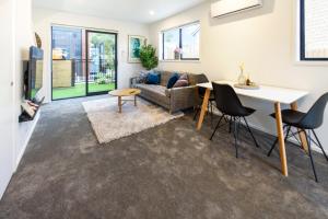 a living room with a couch and a table at Explore Addington and CBD 1 bed w/carpark in Christchurch