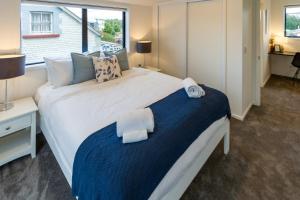 a bedroom with a large white bed and a window at Explore Addington and CBD 1 bed w/carpark in Christchurch
