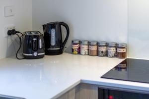 a counter top with a coffee maker and canisters on it at Explore Addington and CBD 1 bed w/carpark in Christchurch