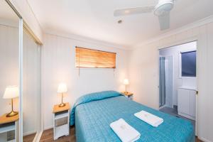a bedroom with a bed with two towels on it at Kingaroy Holiday Park in Kingaroy