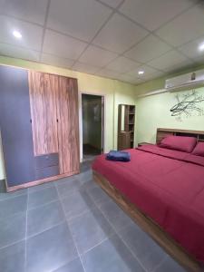 una camera con letto rosso e armadio in legno di Joy Villa Khanom a Khanom