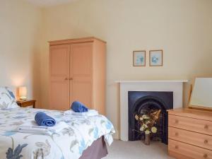 ein Schlafzimmer mit einem Bett und einem Kamin in der Unterkunft Swaleside House in Gunnerside