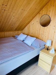 a bed in a room with a wooden wall at Baltic Star in Władysławowo