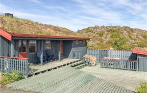 a blue house with a deck with a grass roof at Amazing Home In Offersy With House Sea View in Offersøy
