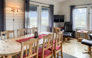 a dining room with a table and chairs and a television at Awesome Home In Offersy With Sauna, Wifi And 3 Bedrooms in Offersøy