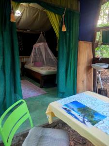 パケラにあるJungle Tent 3x3, Latino Glamping & Tours, Paqueraのテント付きのベッドルーム(ベッド1台、椅子付)
