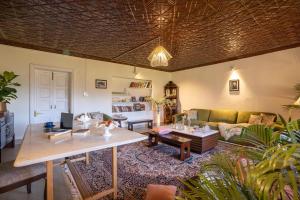 ein Wohnzimmer mit einem Sofa und einem Tisch in der Unterkunft StayVista at Jhelum Kinare in Srinagar