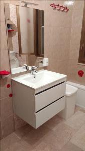 bagno con lavandino, specchio e servizi igienici di Casa Vacanze Arba Girasole a Girasole
