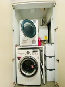 Waschmaschine und Trockner in einem kleinen Zimmer in der Unterkunft Miru House in Seogwipo