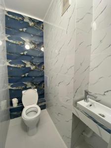 a bathroom with a toilet and a sink at Уютные апартаменты в самом центре города на площади Исатая Махамбета in Atyraū