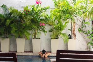 a person in a swimming pool with plants at Casa Gaitana - Alma Hotels in Santa Marta