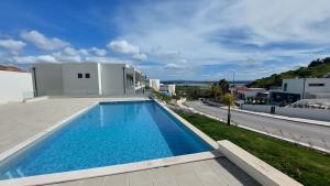 a swimming pool on the side of a house at Fou de Foz in Foz do Arelho