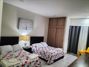 1 dormitorio con 2 camas y puerta de madera en Hotel La Estancia en Río Verde