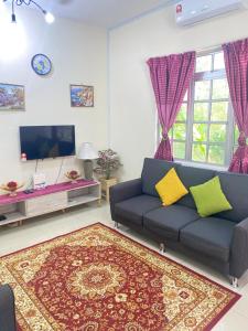a living room with a couch and a tv at Homestay Zalida D Musleem in Kampong Alor Gajah