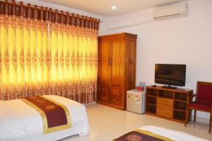 a bedroom with a bed and a flat screen tv at HOTEL LAO CAI 33C CÁT LINH in Hanoi