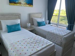 two beds in a room with a balcony at Beach Bliss in Trincomalee +21 photos