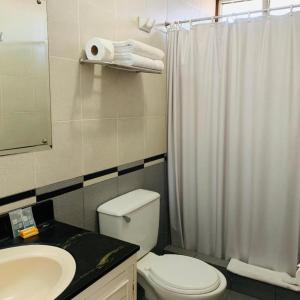 a bathroom with a toilet and a sink and a shower at Hotel Acosta in Iquitos +55 photos