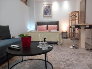 a living room with a bed and a coffee table at Nisos suite in Ermoupoli