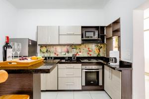 cocina con electrodomésticos de acero inoxidable y encimera en Apartamento turístico Medellín Laureles, By Family Rooms, en Medellín