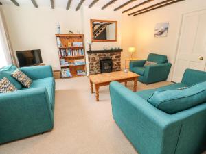 sala de estar con 2 sofás azules y chimenea en The Chace, en Redruth